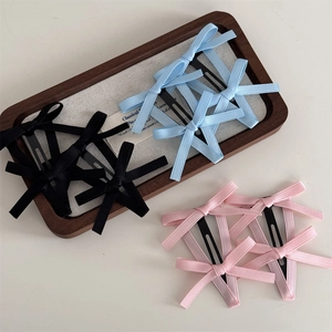 Set di fermagli per capelli con fiocchi di raso in nero, azzurro e rosa su vassoio