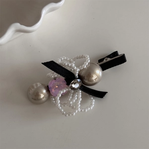 Detail of elegant pearl bow hair clip with champagne beads and pink crystal accent