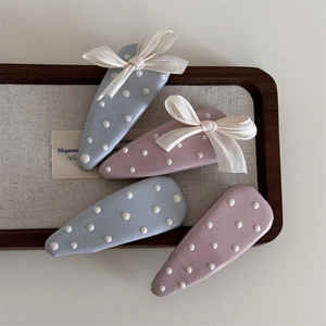 Fermagli per capelli BB a pois blu e rosa con fiocchi su vassoio di legno
