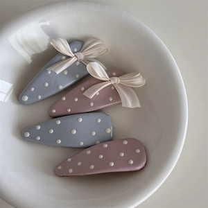 Dettaglio di quattro fermagli per capelli blu e rosa a pois con fiocchi in chiffon