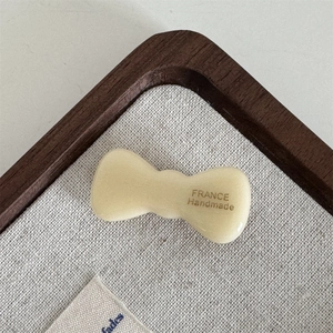 Close-up of cream acetate bow hair clip featuring France Handmade engraved text