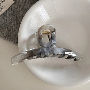 Detail of grey marble ink pattern acetate hair claw clip with gold metal spring