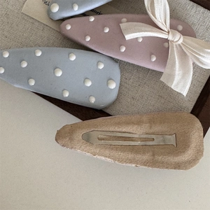 Dettaglio del retro in feltro e fiocco delle mollette a pois blu per le donne