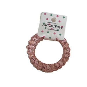 Pink spiral hair tie with floral patterns and a polka dot tag on a clean background