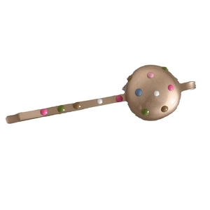 Minimalist gold metal hair clip with colorful colorful polka dots on white background