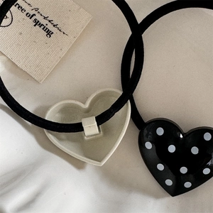 Detail shot of heart-shaped polka dot hair tie with strong elastic band and smooth finish
