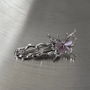 Vue détaillée de la pince papillon argentée avec opales roses et strass brillants