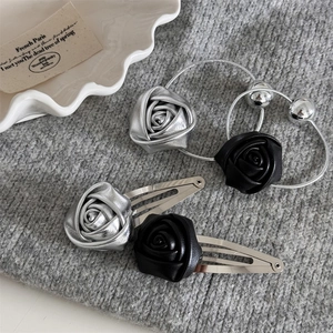 Close-up of leather rose hair clips and ties set on a textured knitted sweater background