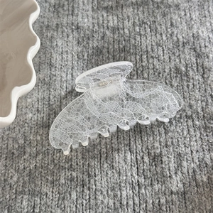 Détail de la pince à cheveux haut de gamme avec motif dentelle sur fond en tricot gris