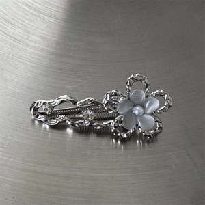 Vue détaillée de la pince à cheveux fleur argentée avec strass et perles en résine opale