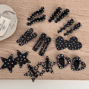 Macro detail of assorted black hair clips with colorful polka dots in various geometric shapes