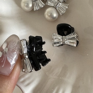 Vue macro d'une barrette nœud en strass avec finition noire brillante sur perles