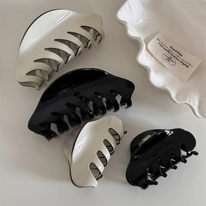 Detailed view of large and small black and white minimalist French hair claw clips