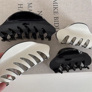 Classic French claw hair clips in glossy black and white for elegant hairstyles
