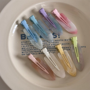 7Pcs colorful seamless hair clips with marble texture in a white ceramic dish