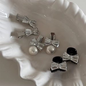 Détails de barrettes nœuds en strass et perles sur un plateau décoratif nacré