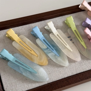 Macro detail of macabre pastel resin hair clips with elegant marble and glitter finish