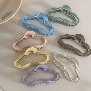 Set of 7 colorful matte wavy claw clips in Morandi tones on a minimalist background