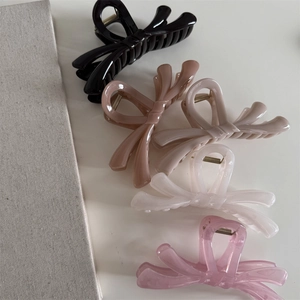 Lot de cinq pinces à cheveux en forme de nœud colorées en noir, marron, crème et rose