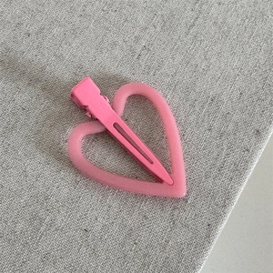 Detail van roze mat hart haarklem met een stevige metalen eendenbek clip voor dagelijks gebruik