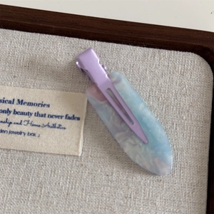 Detailed macro view of a lavender marble acetate hair clip on an elegant linen background
