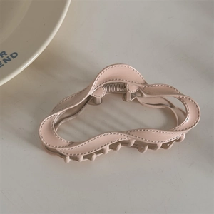 Detail of matte pink wavy alloy hair claw clip with strong metal spring and non-slip teeth
