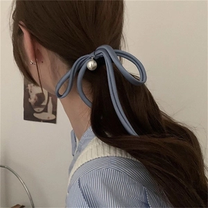 Elegant misty blue ribbon bow hair tie with pearl pendant shown on hair back view