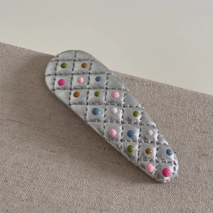 Vue détaillée de la barrette BB en cuir argenté avec des pois colorés