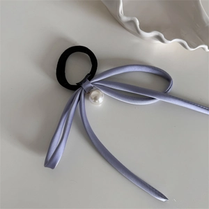Detailed shot of light purple satin ribbon hair tie with elegant white pearl pendant decor
