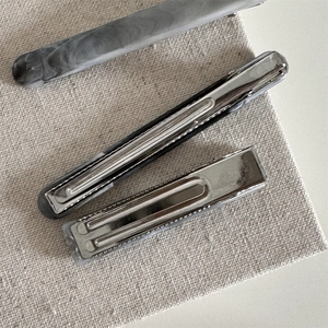 Detail of small gray marble acetate hair claw clip with sturdy silver metal base mechanism