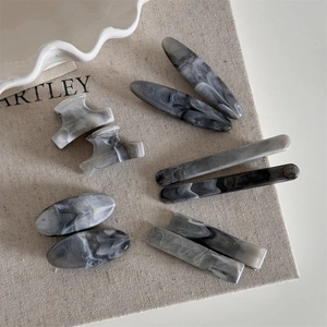 Ink gray marble hair clips set with minimalist acetate texture on linen mat