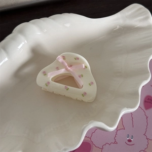 Détail de la pince à cheveux en résine crème avec motif tulipe et nœud en ruban rose
