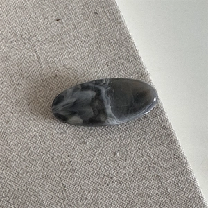 Macro shot of minimalist black and white ink marble pattern hair claw in polished resin