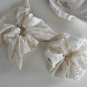 French style cream fabric scrunchies with 3D polka dot texture and brand logo labels