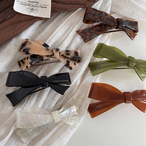 Detailed view of six French acetate bow hair clips in leopard and solid color textures