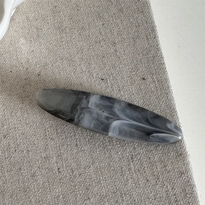 Detailed macro view of the small oval hair claw clip with grey ink marble texture