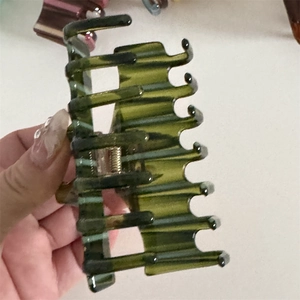 Detail of a large dark green translucent hair claw clip for thick hair styling