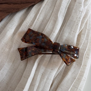 Detail view of acetate tortoise shell bow hair clip with France Handmade lettering