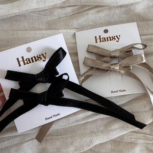 Détail de barrettes à cheveux élégantes avec nœuds en satin noir et champagne