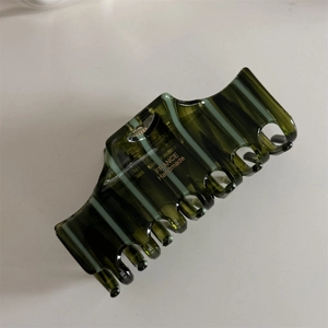 Detailed macro view of olive green striped resin hair claw with France Handmade text
