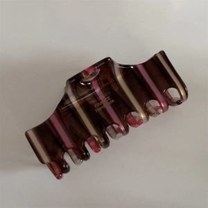 Detail of acetate hair claw with brown stripes and gold France Handmade lettering