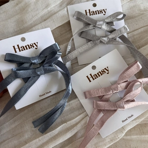 Trois paires de barrettes à nœuds faites main élégantes en gris et rose sur tissu en lin