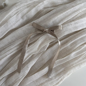 Détail de la texture d'un nœud papillon en soie champagne sur fond de tissu élégant