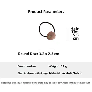 Detail view of pink acetate hair tie with gold oval charm and dimensions 3.2x2.8cm