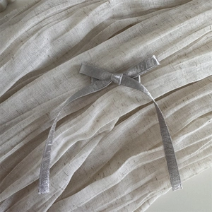 Détail d'un nœud papillon argenté pailleté montrant une texture métallique fine