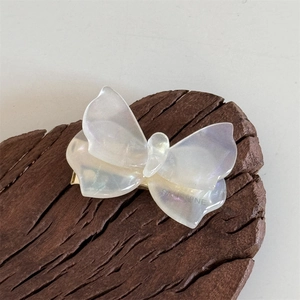Dettaglio del fermaglio per capelli a farfalla perlato con clip in metallo dorato