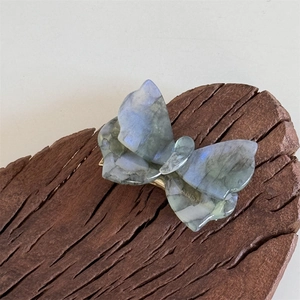Dettaglio del fermaglio per capelli a farfalla in acetato con finitura blu cangiante