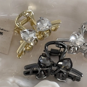 Detailed macro view of rhinestone bow mini hair clips in gold, silver and gun black
