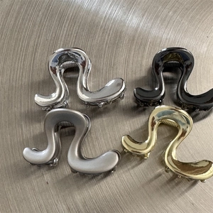 Lot de quatre pinces à cheveux irrégulières en métal en forme de S, or, argent et noir