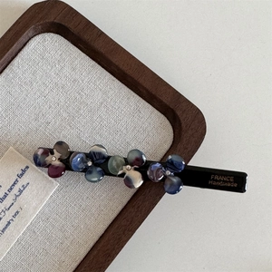Close-up of acetic acid flower hair clip with rhinestones and France Handmade text